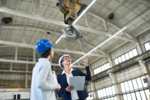 two women in a warehouse looking at a construction crane